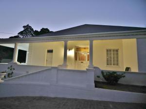 a white house with a front porch and stairs at Lilibet Lodge in Graaff-Reinet
