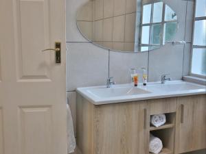 a bathroom with a sink and a mirror at Lilibet Lodge in Graaff-Reinet