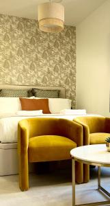 een slaapkamer met een bed en een gele bank bij Tennessee Petit Málaga in Málaga