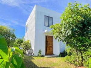 a white house with a wooden door in a yard at Happy Place in Arsenal