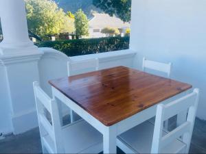 a wooden table and two chairs in front of a window at Lilibet Lodge in Graaff-Reinet +24 photos