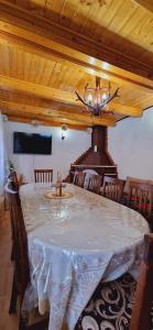 ein Esszimmer mit einem Tisch und einem Kronleuchter in der Unterkunft Casa Bilașco in Ocna Şugatag