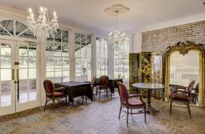 a dining room with a table and chairs and a mirror at The Inn at Cedar Grove in Vicksburg