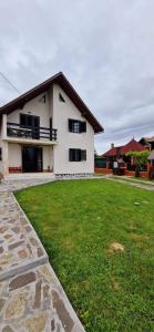 ein weißes Haus mit grünem Rasen davor in der Unterkunft Casa Bilașco in Ocna Şugatag