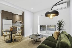 a living room with a green couch and a table at Stylish Open-Space Studio by Jean Talon Market in Montréal +4 photos