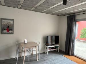 a dining room with a table and a tv at BeliHouse in Trafaria