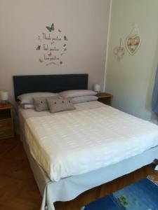 a bedroom with a large bed with white sheets at A casa di Fabio in Biella