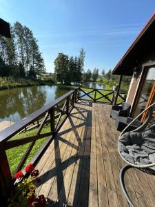 a wooden deck with a view of a river at Brīvdienu māja Straumēni in Pāle