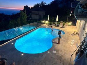 a group of people standing in a swimming pool at night at BB Santalucia in Agerola