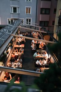 un gruppo di persone sedute ai tavoli di un ristorante di Boutiquehotel Weisses Rössl a Innsbruck Altre 37 foto