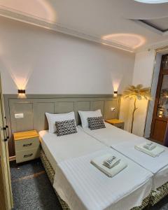 a bedroom with two beds with white sheets and pillows at Hayati HOTEL in Samarkand