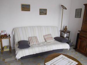 a living room with a white couch with pillows at Appartement Frejus Plage in Fréjus