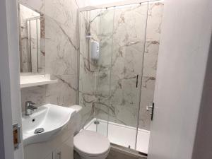 a bathroom with a shower and a toilet and a sink at Skyline Studios Maida-Vale in London
