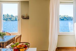 a bowl of fruit on a table in front of a window at Mediterraneo Seaview Apartments in Rovinj