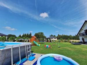 a backyard with a swimming pool and a playground at Złote Gąski in Gąski