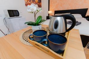 - un plateau avec des tasses et une bouilloire sur une table dans l'établissement Orange Room, à Milan 19 autres photos
