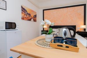 un comptoir de cuisine avec un plateau de tasses à café et un micro-ondes dans l'établissement Orange Room, à Milan