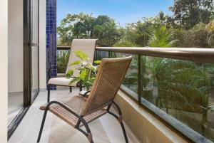 a balcony with a chair and a plant on it at Duplex Beach Service Pool Nature in Riviera de São Lourenço