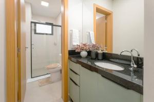a bathroom with a sink and a toilet at Lindo Moderno e Central TV102 in Maringá