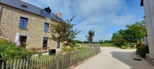 an old brick house with a fence next to it at Les Grands Gîtes de Cancale, gîtes de charme avec jacuzzi in La Coudre