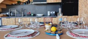 a table with plates and wine glasses on it at Les Grands Gîtes de Cancale, gîtes de charme avec jacuzzi in La Coudre