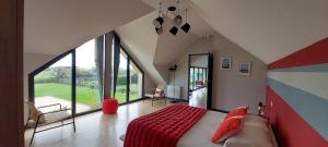 a bedroom with a large bed and a large window at Les Grands Gîtes de Cancale, gîtes de charme avec jacuzzi in La Coudre