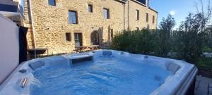 a hot tub in front of a building at Les Grands Gîtes de Cancale, gîtes de charme avec jacuzzi in La Coudre