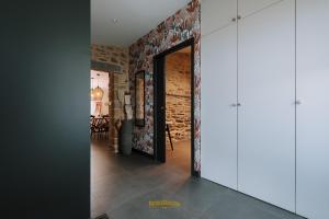 a hallway with a door leading to a dining room at Les Grands Gîtes de Cancale, gîtes de charme avec jacuzzi in La Coudre