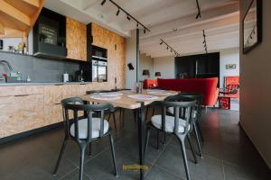 a dining room with a wooden table and chairs at Les Grands Gîtes de Cancale, gîtes de charme avec jacuzzi in La Coudre