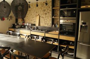 a kitchen with a table and chairs and a stove at Les Grands Gîtes de Cancale, gîtes de charme avec jacuzzi in La Coudre