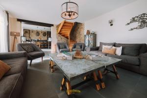 a living room with a couch and a table at Les Grands Gîtes de Cancale, gîtes de charme avec jacuzzi in La Coudre