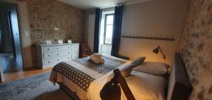a bedroom with a bed with a teddy bear on it at Les Grands Gîtes de Cancale, gîtes de charme avec jacuzzi in La Coudre