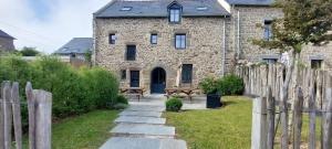 an old brick house with a bench in front of it at Les Grands Gîtes de Cancale, gîtes de charme avec jacuzzi in La Coudre