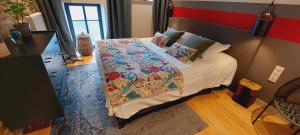 a bedroom with a bed and a dresser with a red wall at Les Grands Gîtes de Cancale, gîtes de charme avec jacuzzi in La Coudre