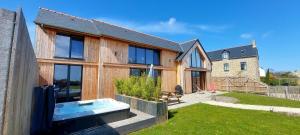 a wooden house with a hot tub in the yard at Les Grands Gîtes de Cancale, gîtes de charme avec jacuzzi in La Coudre
