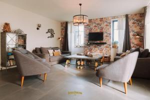 a living room with a couch and a table at Les Grands Gîtes de Cancale, gîtes de charme avec jacuzzi in La Coudre
