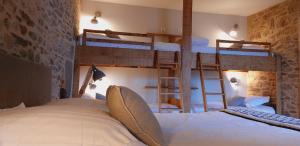 a bedroom with two bunk beds in a room at Les Grands Gîtes de Cancale, gîtes de charme avec jacuzzi in La Coudre