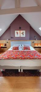 a bedroom with a large bed in a attic at Les Grands Gîtes de Cancale, gîtes de charme avec jacuzzi in La Coudre