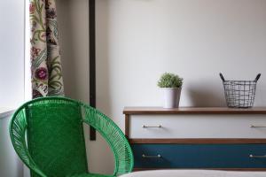 a green chair in front of a desk at Les Grands Gîtes de Cancale, gîtes de charme avec jacuzzi in La Coudre