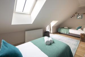 a attic bedroom with two beds and a window at Les Grands Gîtes de Cancale, gîtes de charme avec jacuzzi in La Coudre