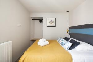 a bedroom with a bed with a yellow blanket at Les Grands Gîtes de Cancale, gîtes de charme avec jacuzzi in La Coudre