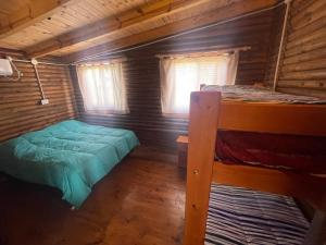 Villa La RiveraにあるCABAÑAS COSTA RIBERAの丸太小屋の二段ベッドが2つある寝室