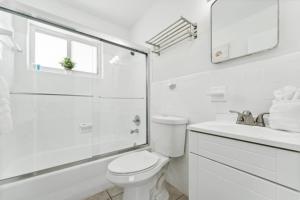 a white bathroom with a toilet and a sink at Catalina by the Beach 6 in Pompano Beach +40 photos