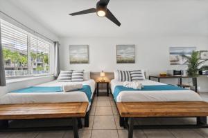 two beds in a room with a ceiling fan at Catalina by the Beach 6 in Pompano Beach