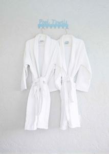 two white coats are hanging on a wall at Royal Retreat Pool Hot Tub in Royal Palm Beach