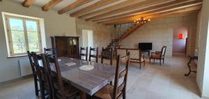 a dining room with a wooden table and chairs at Fermette Tourangelle in Bréhémont