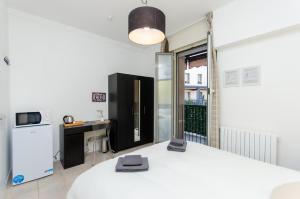 une chambre avec un lit blanc et une cuisine dans l'établissement Yellow Room, à Milan