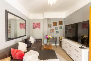 a living room with a couch and a large mirror at Traditional English 4 bedroom home in Greenwich in Plumstead