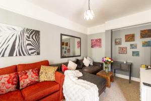 a living room with a couch and a mirror at Traditional English 4 bedroom home in Greenwich in Plumstead +22 photos