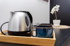une cafetière et deux tasses sur un plateau en bois dans l'établissement Yellow Room, à Milan